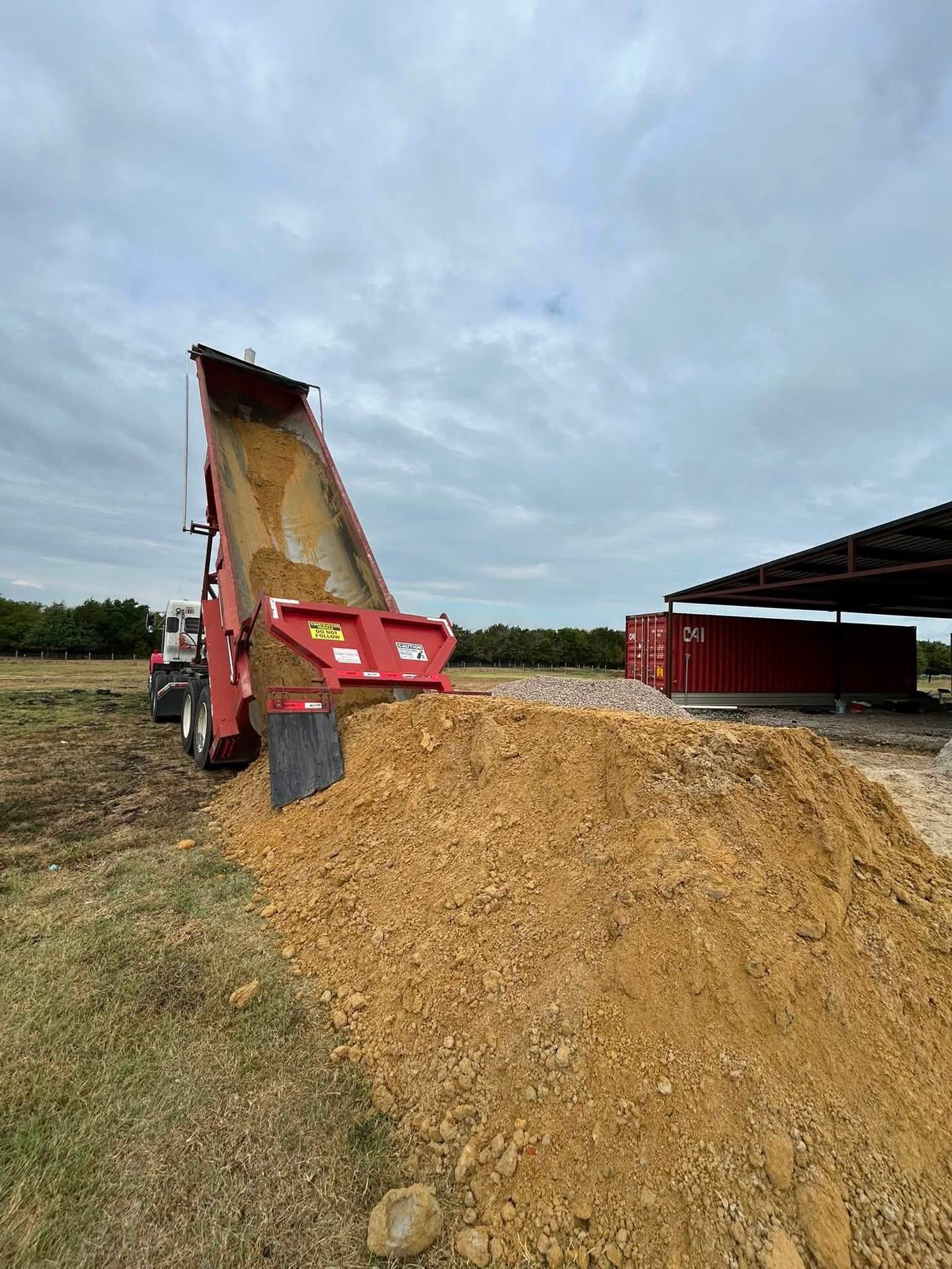 Dump truck delivering topsoil for a dirt work project